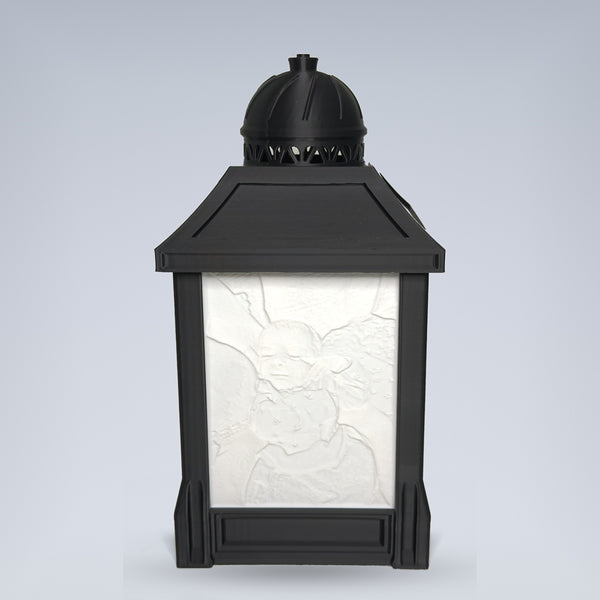 Custom lithophane photo lamp — black 3D printed lantern by day with sculpted photo relief panel, studio background