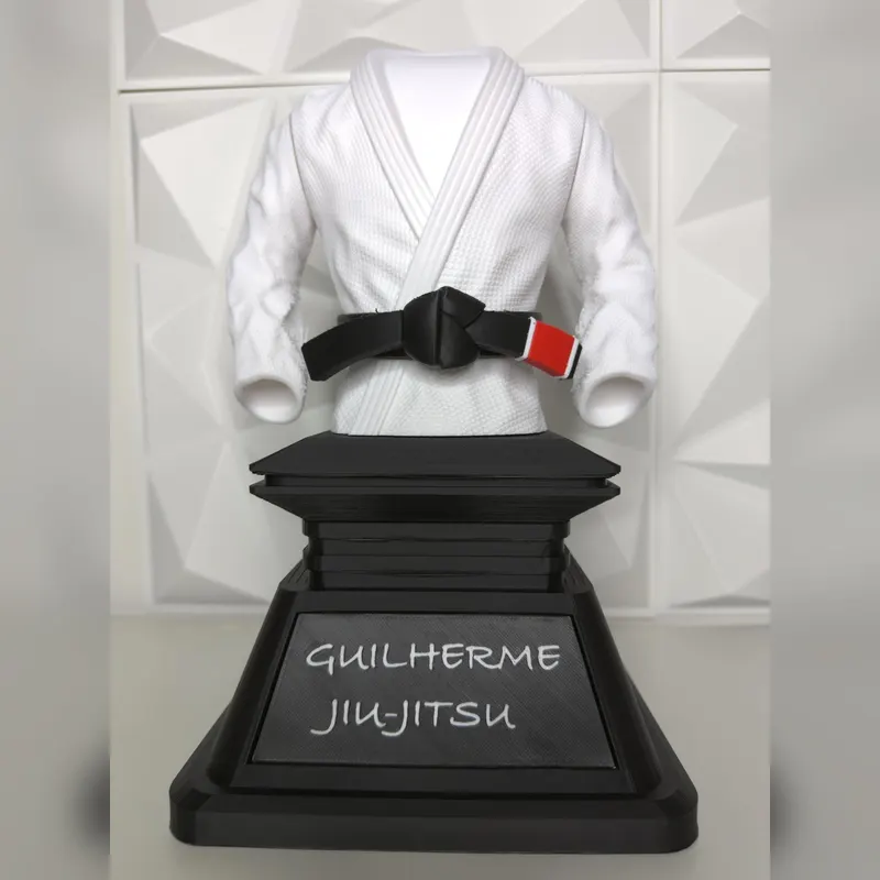 Gi trophy with personalised GUILHERME JIU-JITSU plaque against a white wall