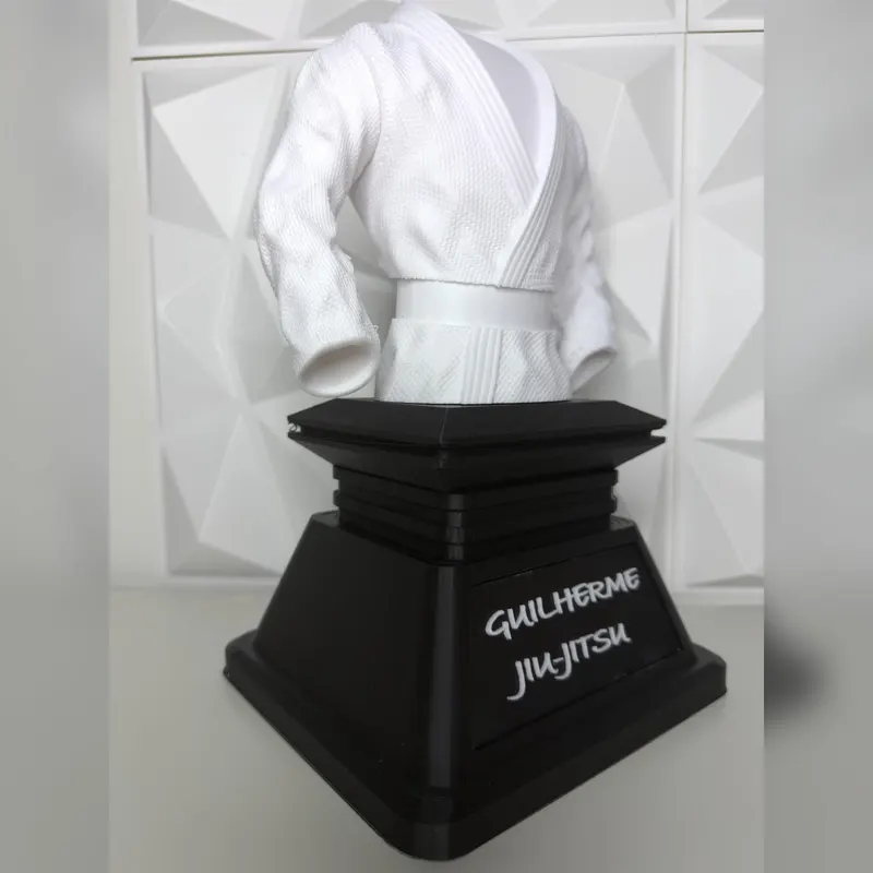 Jiu-jitsu gi trophy seen from an angle, showing the engraved name plaque