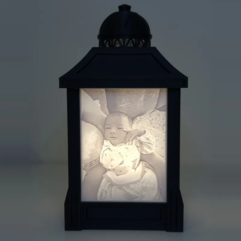 The same lithophane lamp switched on, revealing a baby photo in glowing detail